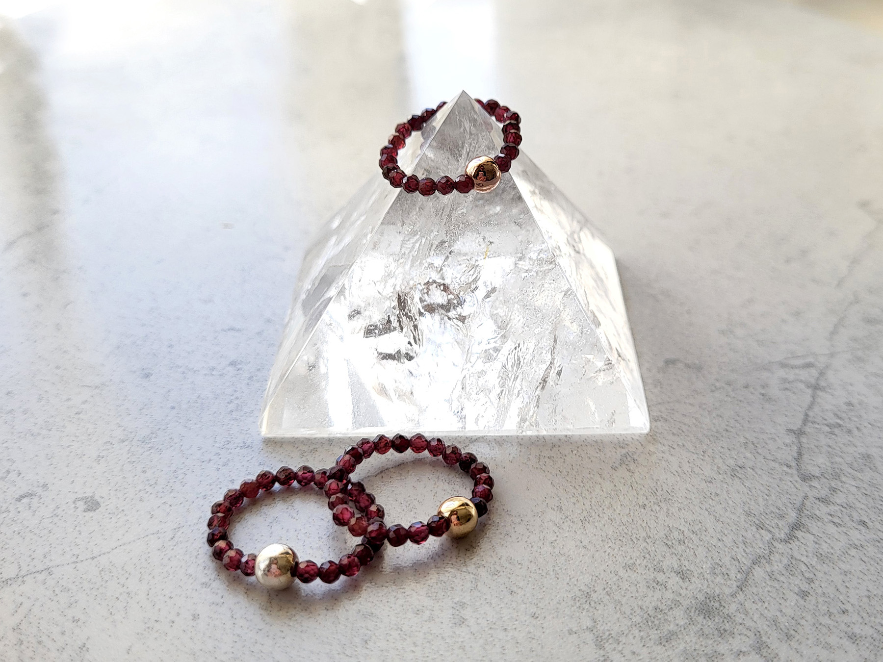 Image of garnet beaded stretch rings showcasing three different types of metal: 925 sterling silver, gold-filled, and rose gold-filled.